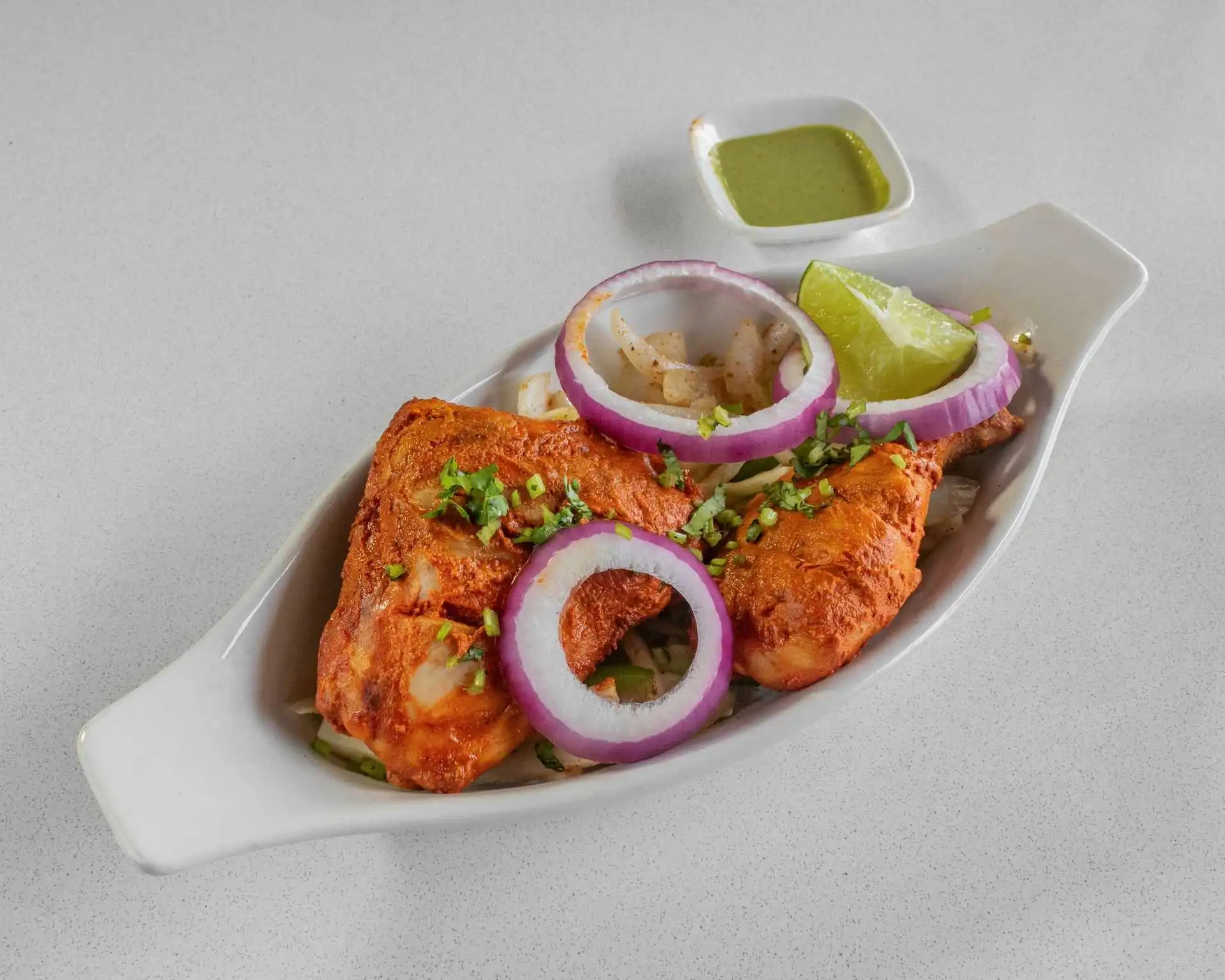 Tandoori chicken served with onion and lime at Rockfort Authentic Chettinadu & Indian Cuisine, Calgary